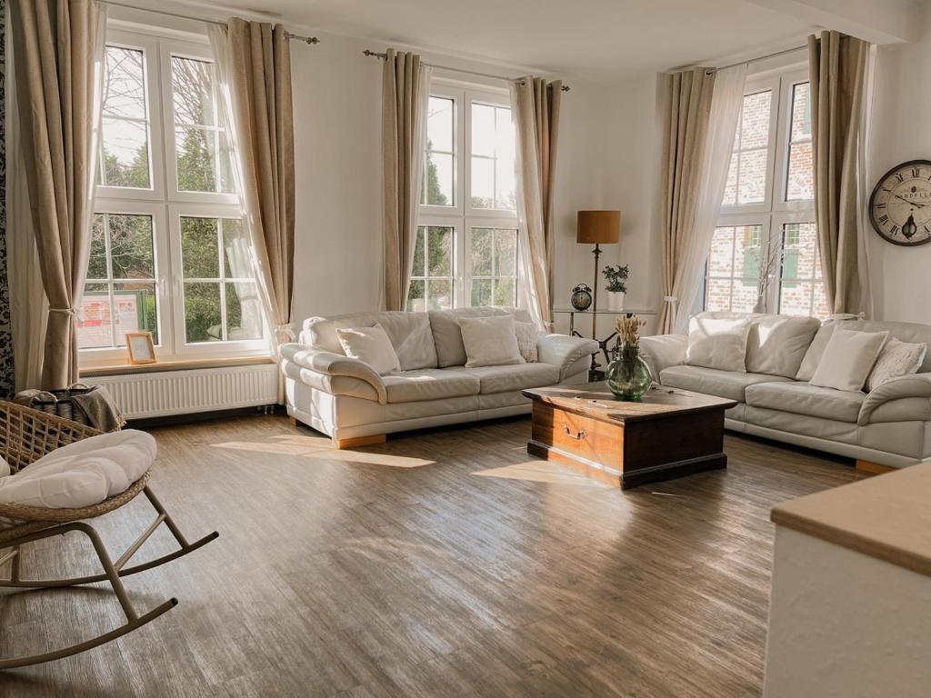 ein Wohnzimmer mit zwei Sofas und einem Couchtisch in der Unterkunft "Unnen" in der Alten Schule Greetsiel in Krummhörn