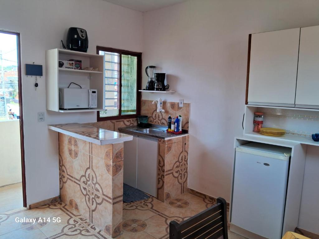a kitchen with a counter and a refrigerator at apartamento só pra vc e sua familia in Belém