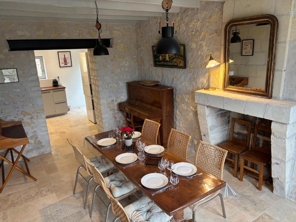 a dining room with a table and a fireplace at Gîte les Huttières in Cravant-les-Coteaux