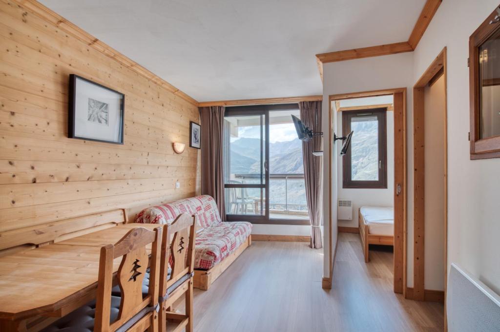 una sala de estar con un sofá y una mesa en Appartement N° 46, en Les Menuires