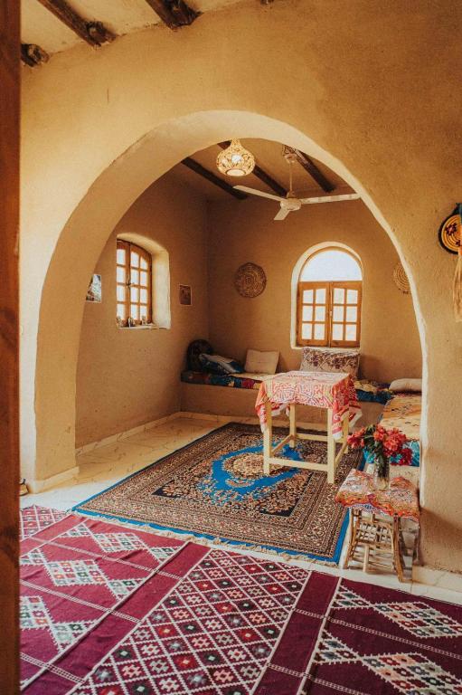 a living room with a table and a rug at Desert Rose Guesthouse in Luxor