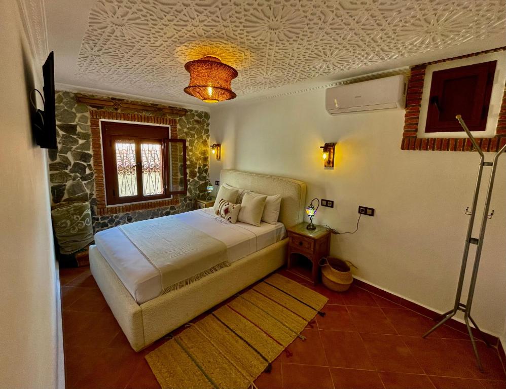 a bedroom with a bed and a television in it at Riad abi khancha in Chefchaouen