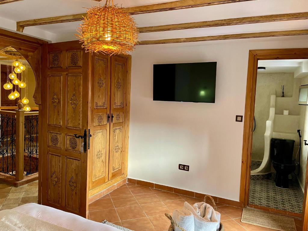 a living room with a tv on a wall at Riad abi khancha in Chefchaouen