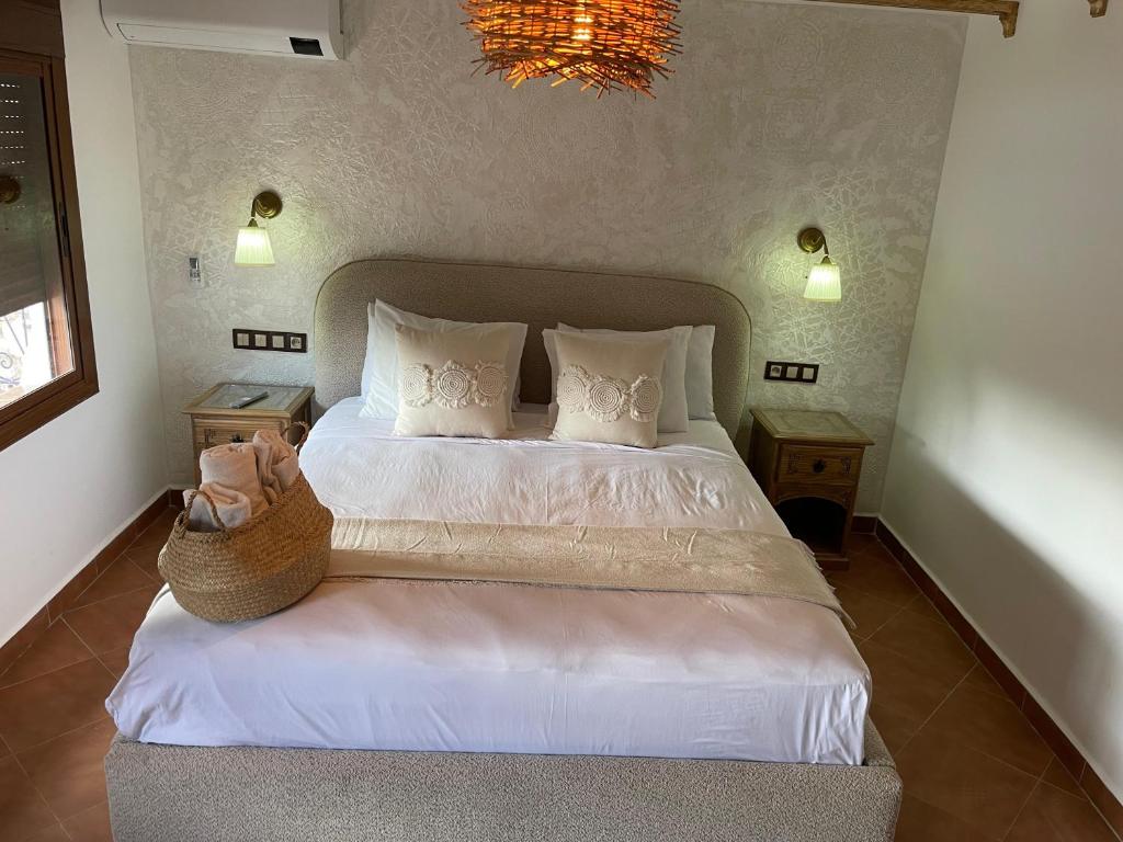 a bedroom with a bed with white sheets and pillows at Riad abi khancha in Chefchaouen