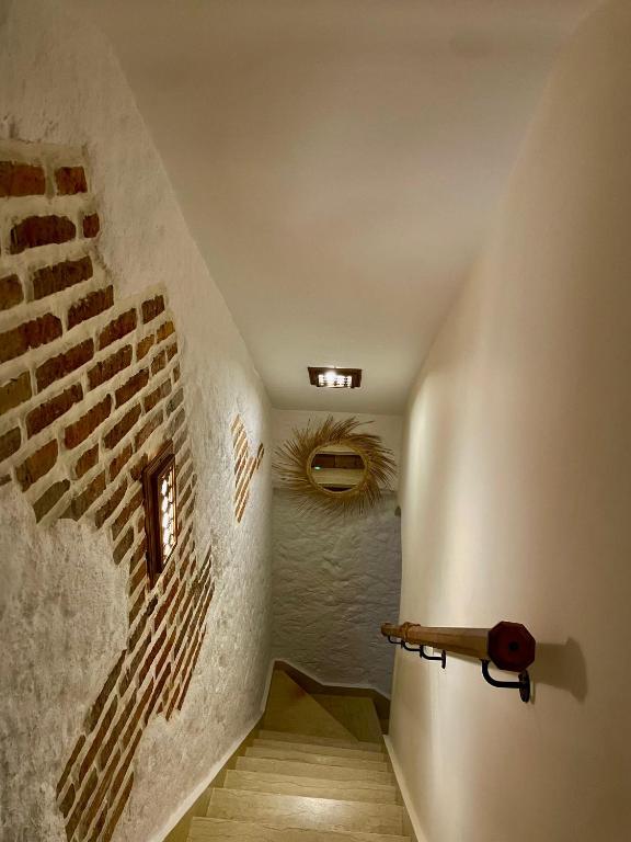 a room with a staircase with a brick wall at Riad abi khancha in Chefchaouen