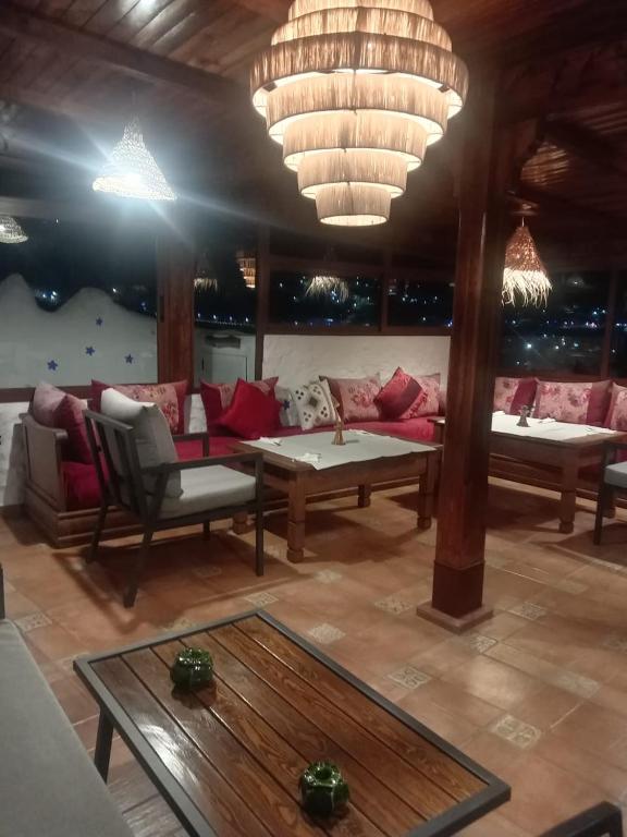 a living room with a couch and tables and chandeliers at Riad abi khancha in Chefchaouen