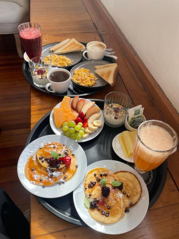 a table with plates of breakfast food on it at Hotel boutique Paihuen in Valparaíso