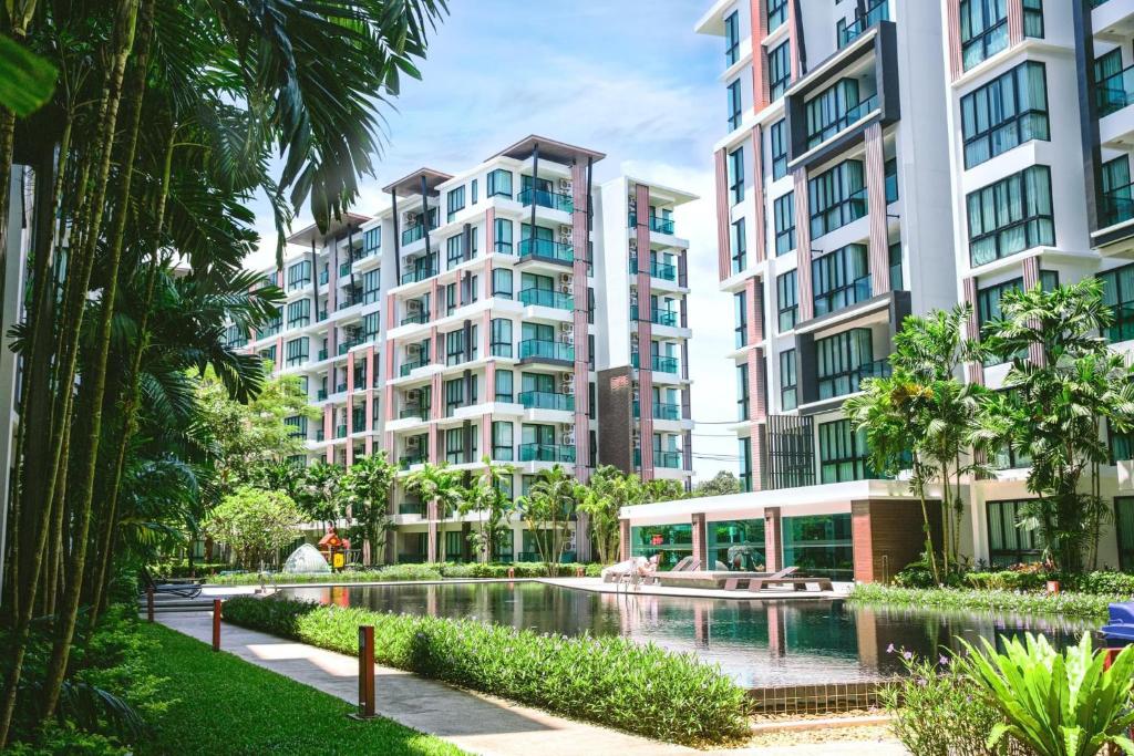 an apartment complex with a pool in front of buildings at Royal Lee Phuket Condominium Airport in Ban Bo Han