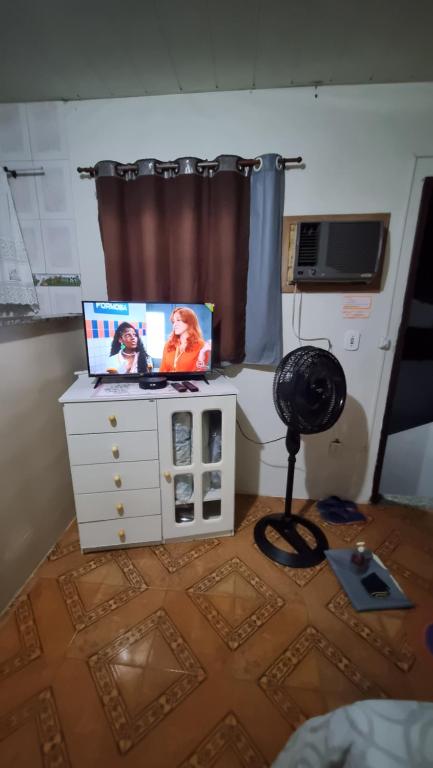 a room with a dresser with a tv on it at Kitnet em ambiente familiar in São Pedro da Aldeia