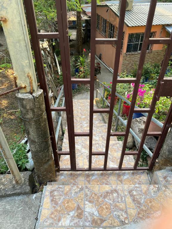 an open gate leading into a garden with flowers at Aguiñada's House in El Rosario