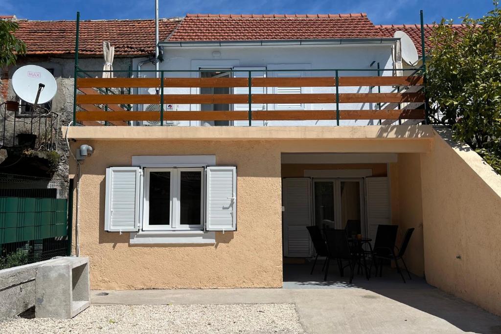 a small house with a window and a patio at Holiday house with a parking space Bilice, Krka - 24006 in Šibenik