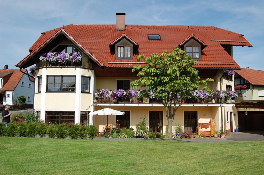 ein großes Haus mit Blumen auf den Balkonen in der Unterkunft Gästehaus Am Sonnenhang in Erbendorf