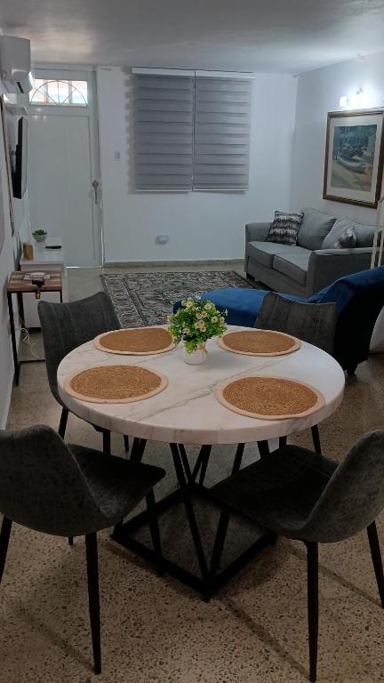sala de estar con mesa con sillas y sofá en San Antonio, en Aguas Buenas