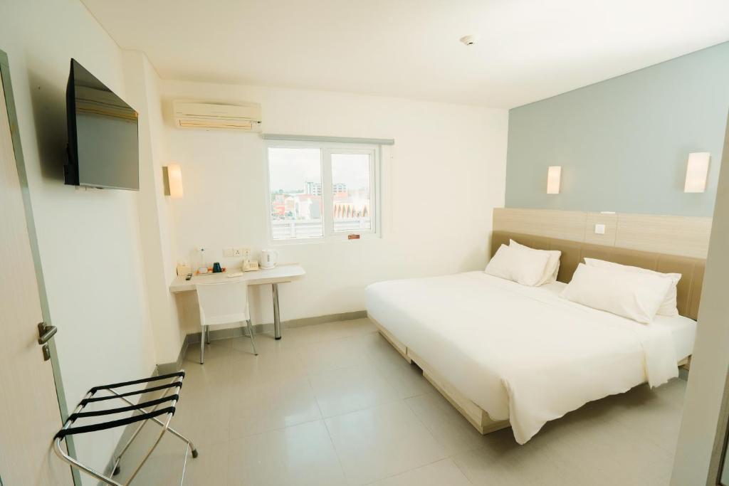 Postel nebo postele na pokoji v ubytování Carani Hotel Yogyakarta