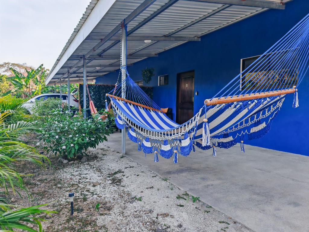a blue house with a hammock in front of it at Casa Celeste Río Grande in Paquera