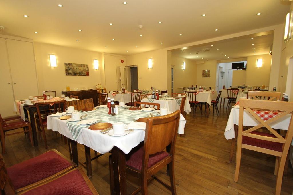 a restaurant with tables and chairs with white table cloth at Ridgemount Hotel in London