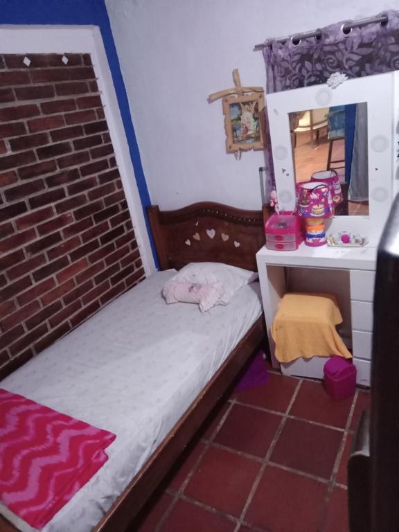 a small bedroom with a bed and a mirror at Apartamento Cueva del OSO II in San Cristóbal