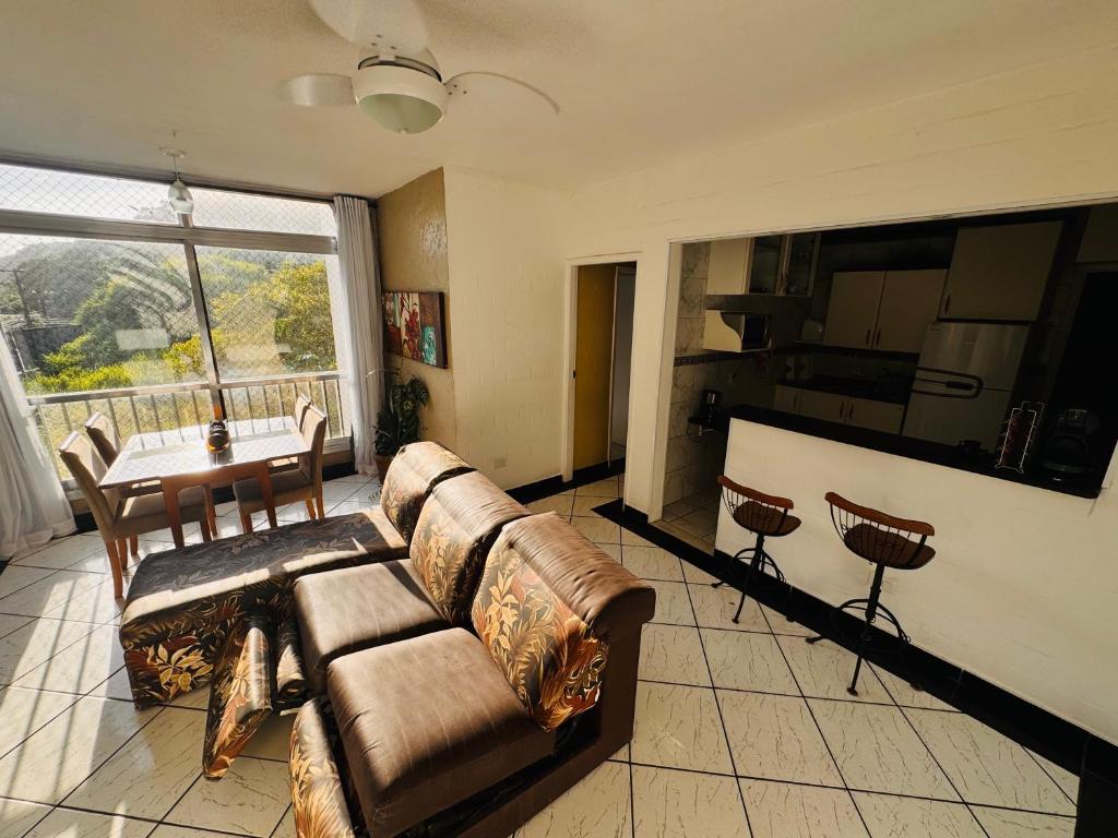 a living room with a couch and a table at Apartamento em Guarujá - Praia da Enseada in Guarujá