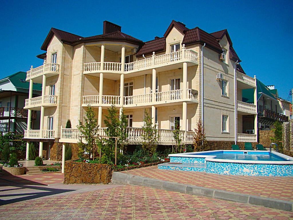a large building with a swimming pool in front of it at Buhta Udachi Mini-hotel in Gelendzhik