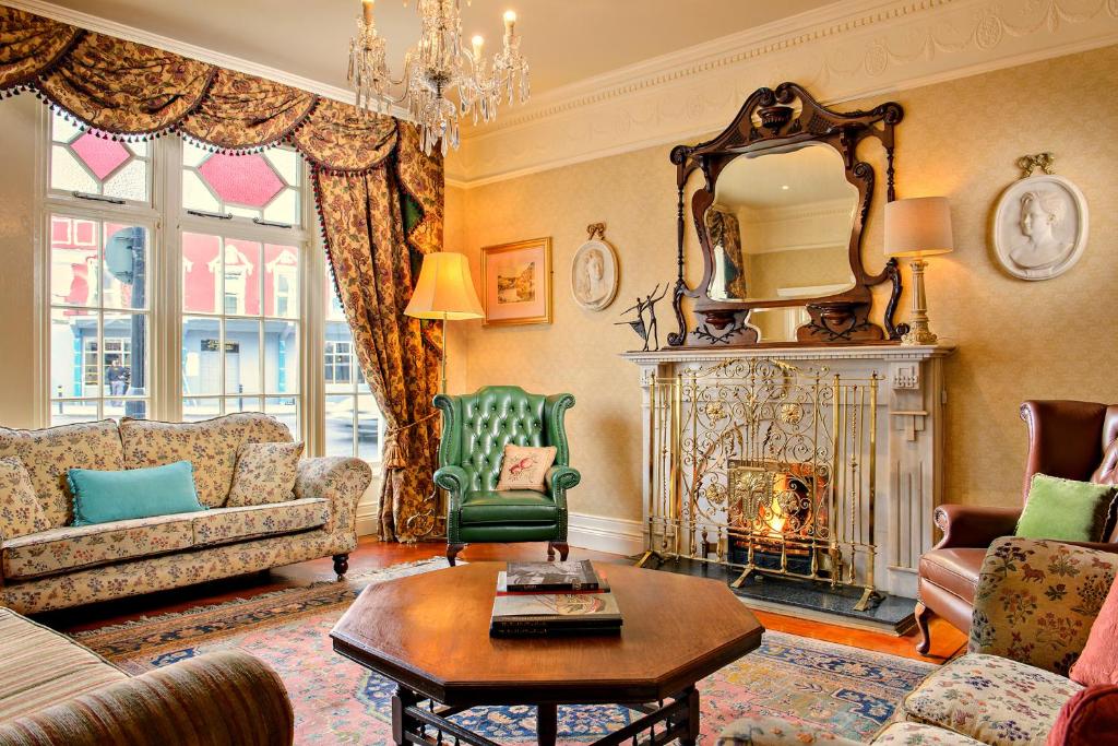 a living room with a couch and a fireplace at Arbutus Hotel in Killarney