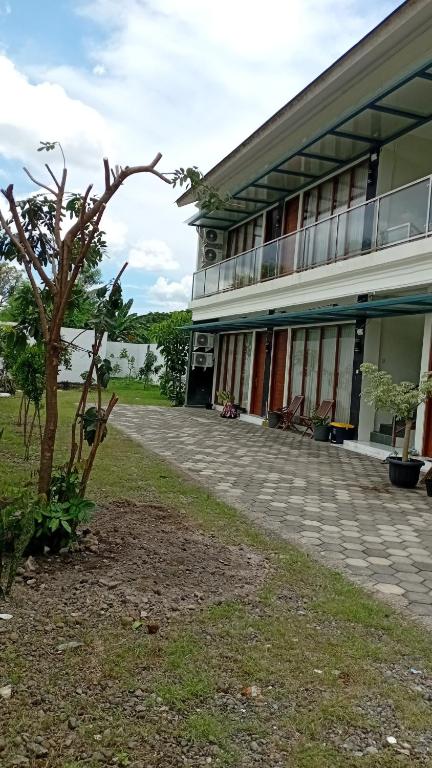 a building with a tree in front of it at Laika Homestay in Gondowulung