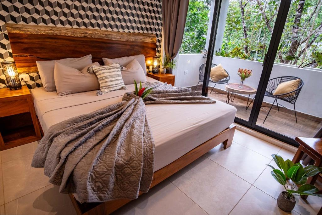 ein Schlafzimmer mit großem Bett und Balkon in der Unterkunft Aqua Viva, Pool, AC, Internet, Beach club in Bacalar