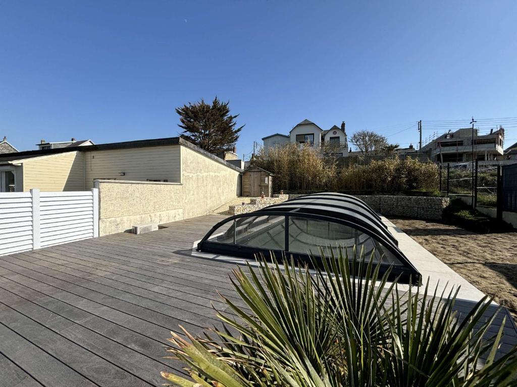 un cenador en la parte superior de un patio en Villa à 150m de la plage avec piscine et WiFi gratuit - FR-1-361-8, en Donville-les-Bains