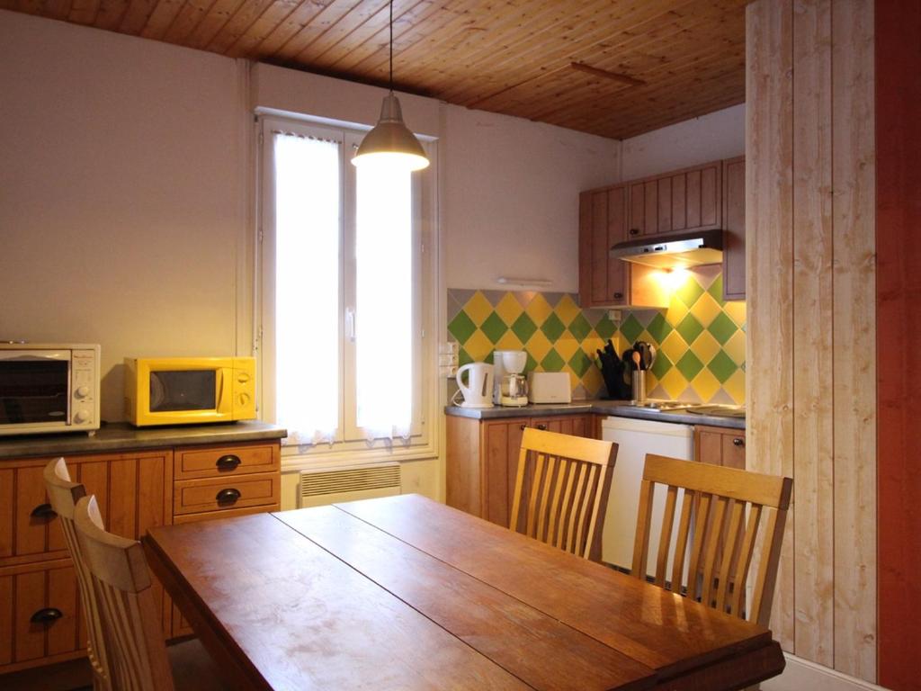 une cuisine avec une table en bois et un micro-ondes dans l'établissement Appartement F3 Mont-Dore à 200m des thermes, parking sécurisé, 4 couchages, sans ascenseur - FR-1-415-61, à Le Mont-Dore