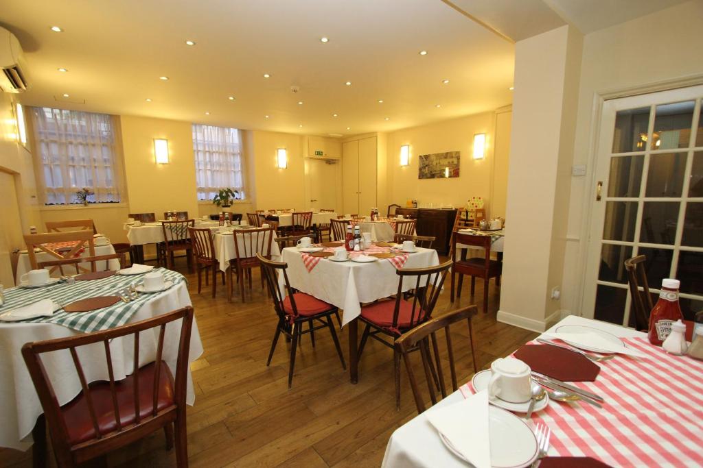 a dining room with tables and chairs in it at Ridgemount Hotel in London