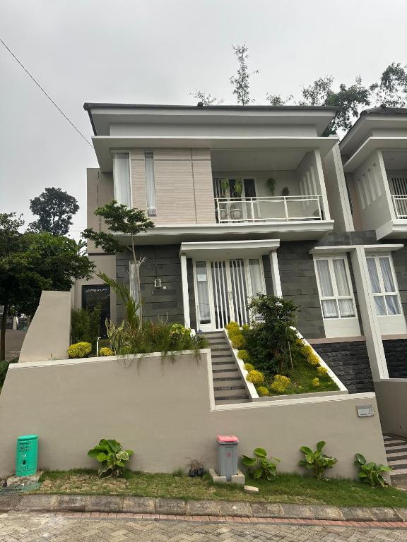 a large house with stairs and plants in front of it at Villa Sunrise F1 in Malang