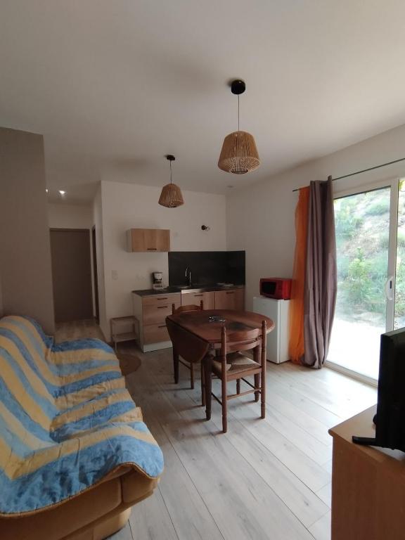 un salon avec une table et un canapé dans l'établissement Appartement des Georges du Tarn, à Compeyre