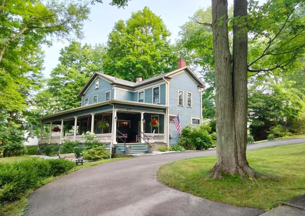 una casa blu con una bandiera su un vialetto di Highland Bed & Breakfast a Meadville