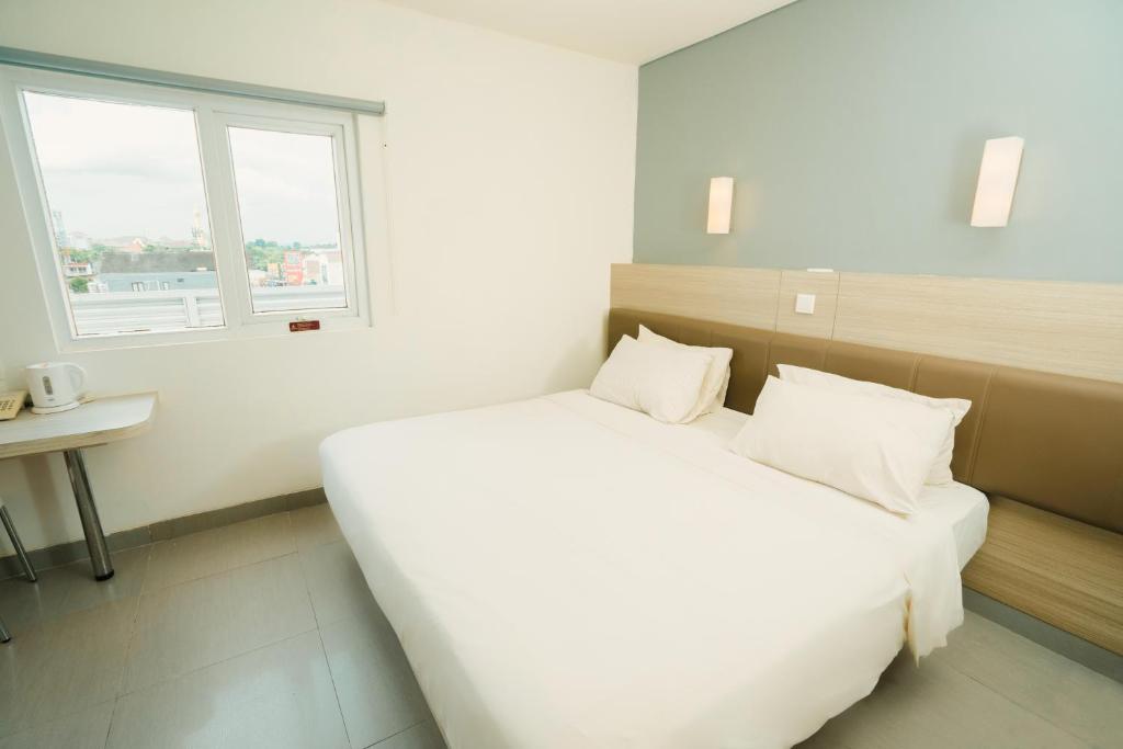 Postel nebo postele na pokoji v ubytování Carani Hotel Yogyakarta
