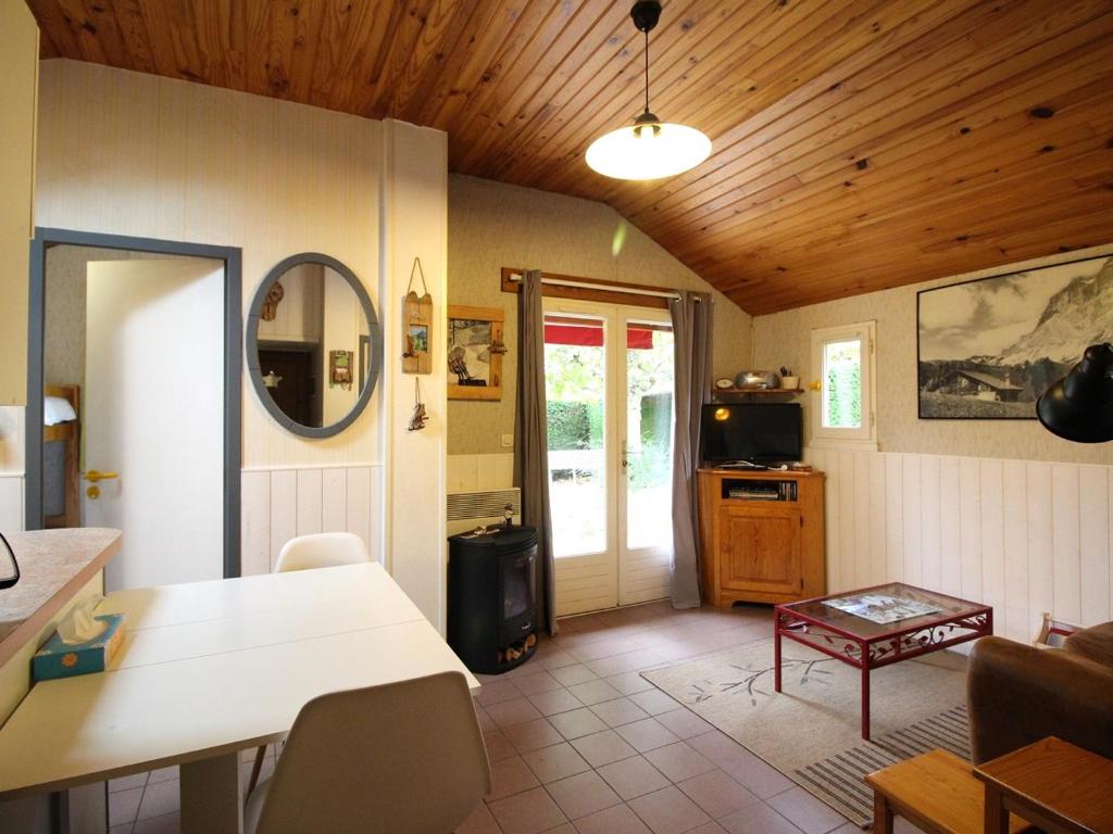 ein Wohnzimmer mit Tisch und ein Esszimmer in der Unterkunft Pavillon calme avec jardin clos, animaux admis, parking, à 2 km du centre de La Bourboule - FR-1-415-156 in La Bourboule