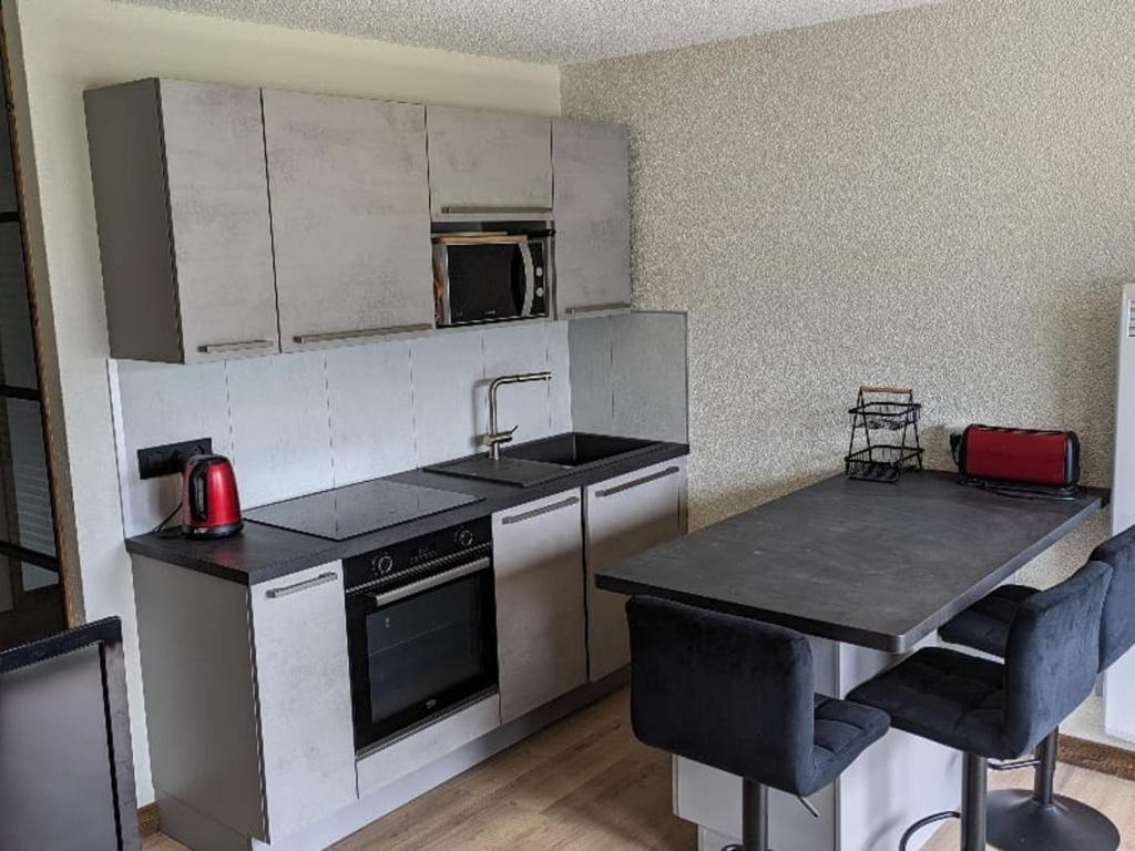 une petite cuisine avec un évier et une cuisinière dans l'établissement Studio confortable à Châtel avec WiFi et parking couvert - FR-1-676-215, à Châtel