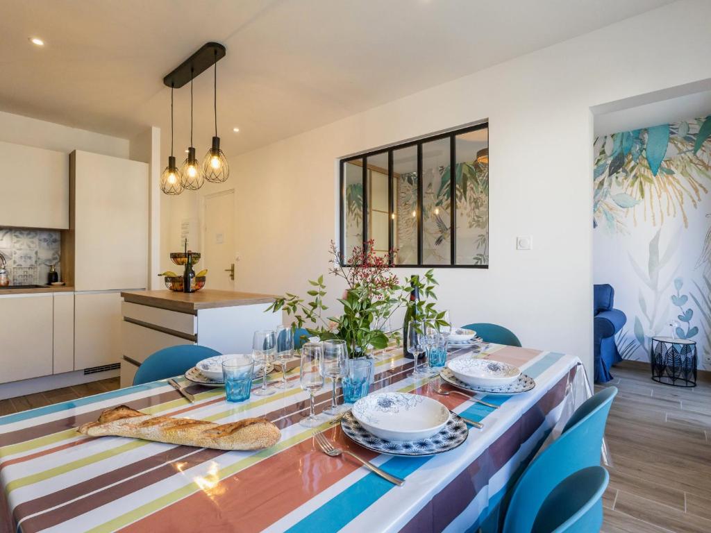 une salle à manger avec une table et des chaises bleues dans l'établissement Charmant duplex rénové au cœur de Lajarrige avec wifi - FR-1-306-1297, à La Baule