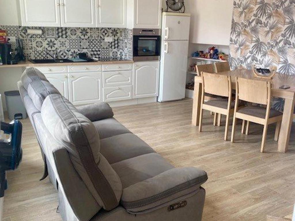 un salon avec un canapé et une table dans une cuisine dans l'établissement F3 Moderne avec Climatisation et WiFi Proche des Thermes - FR-1-703-205, à Amélie-les-Bains-Palalda