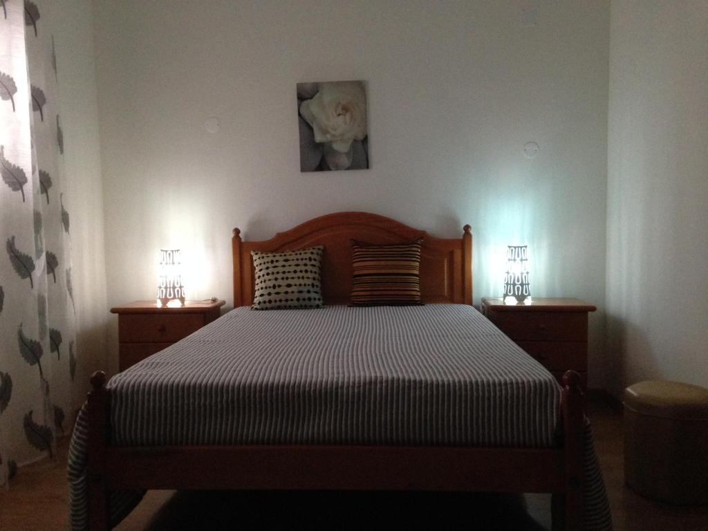 a bedroom with a bed with two nightstands and two lamps at Residencia Salva-Vidas in Nazaré