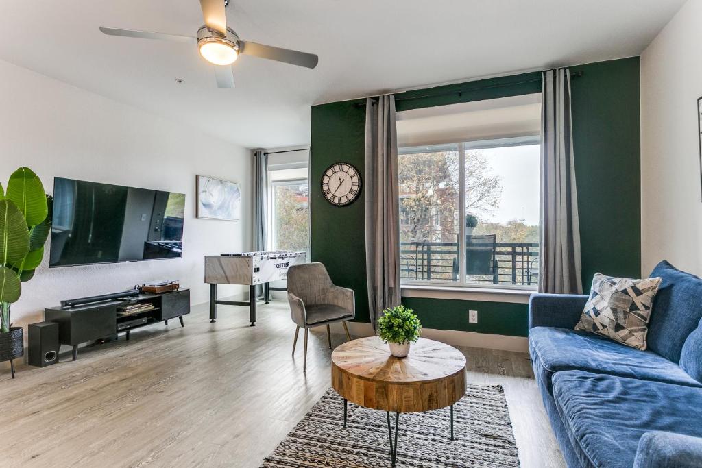 a living room with a blue couch and a table at Modern Cozy Condo facing Riverwalk w King Suite in San Antonio