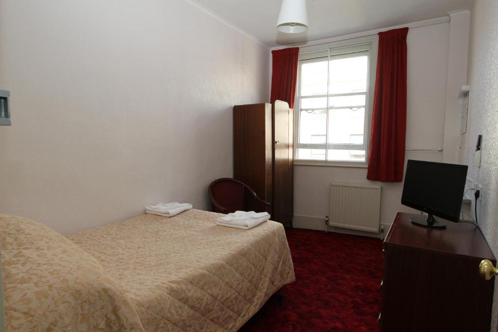a hotel room with a bed and a television at Ridgemount Hotel in London