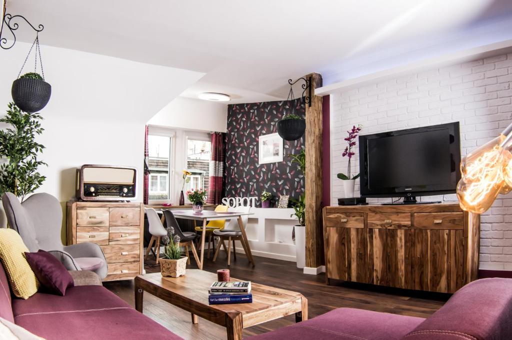 a living room with a couch and a tv at Klimatyczny apartament Salamandra w Sopocie in Sopot