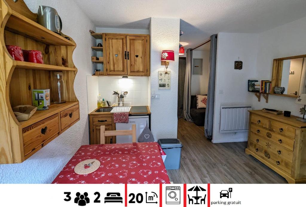 - une petite cuisine avec des placards en bois et une table dans la chambre dans l'établissement studio terrasse de charme près des pistes, à Bernex