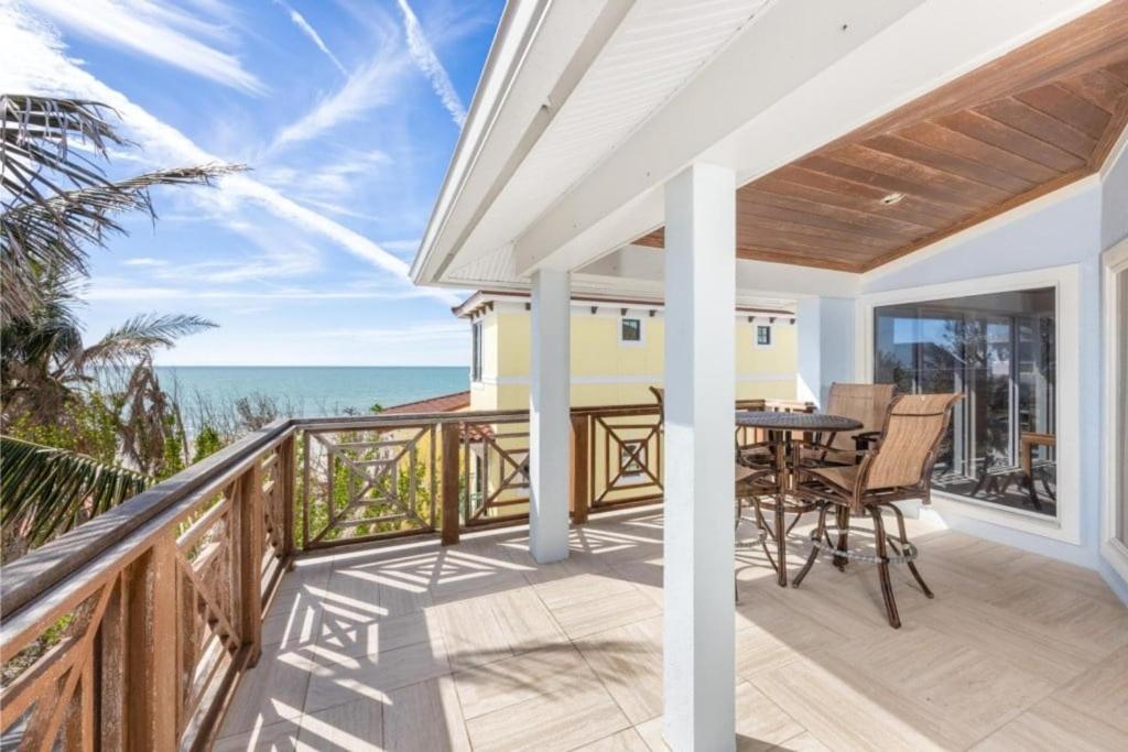 a balcony with a table and chairs and the ocean at Anchored Here home in Captiva