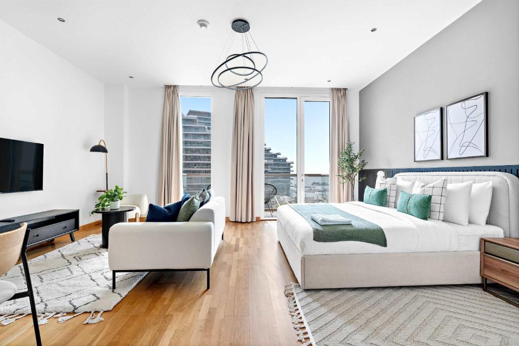 une chambre avec un grand lit et un salon dans l'établissement Silkhaus cozy Studio at Al Bandar Marina with gym, à Abu Dhabi