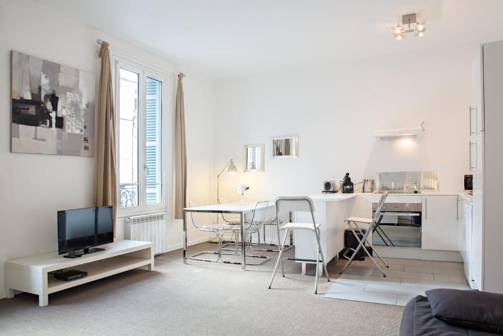 sala de estar blanca con mesa y cocina en Charmant 2 Pièces, en Honfleur