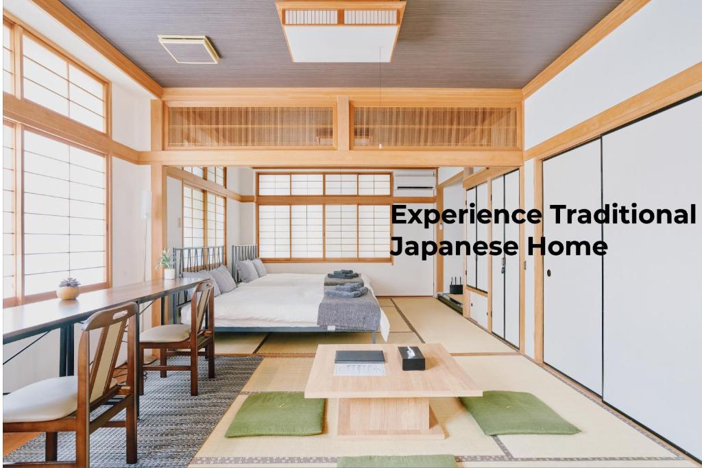 une maison japonaise traditionnelle avec un lit et une table. dans l'établissement Japanese Tradition Hotel Evergreen, à Tokyo