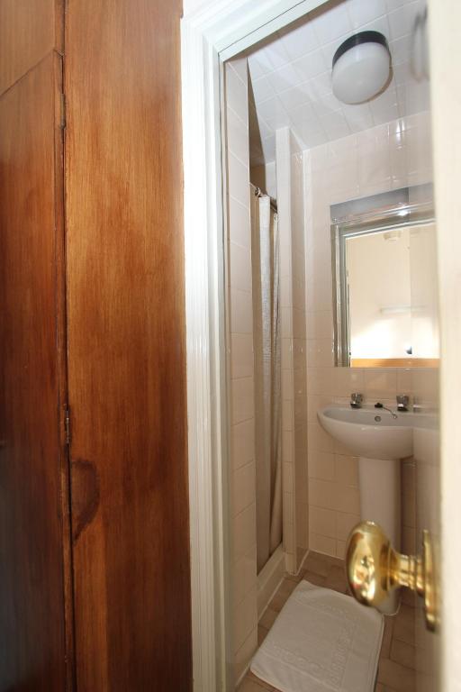 a bathroom with a sink and a toilet and a mirror at Ridgemount Hotel in London