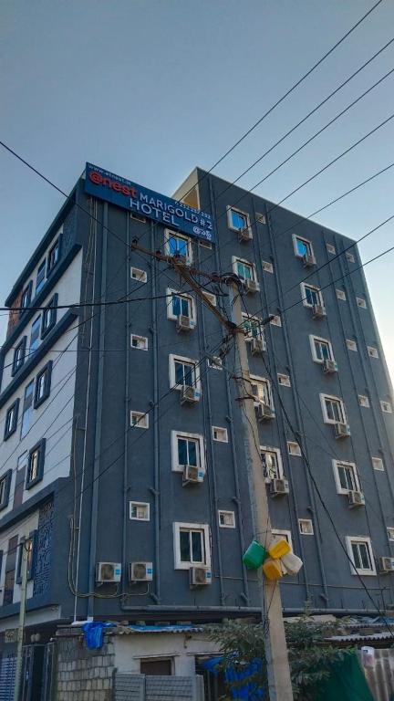 a tall gray building with a sign on it at Hotel Marigold Kokapet- A Business Hotel in Hyderabad