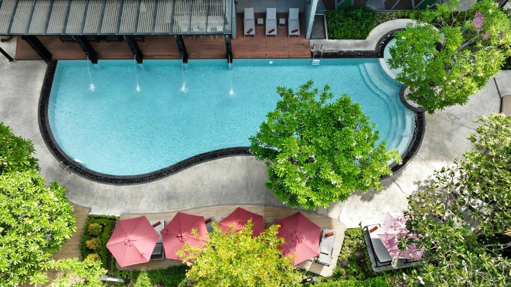 an overhead view of a swimming pool with pink umbrellas at Altera Hotel and Residence by At Mind in Pattaya
