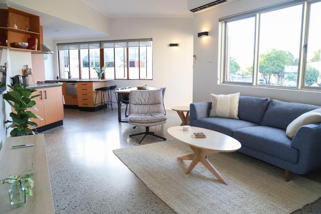 a living room with a blue couch and a table at Ellen City Centre in Fremantle